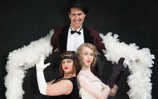 Promo for Chicago with male with boa and two females in costume