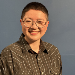 person wearing glasses and collared shirt, dark hair, smiling
